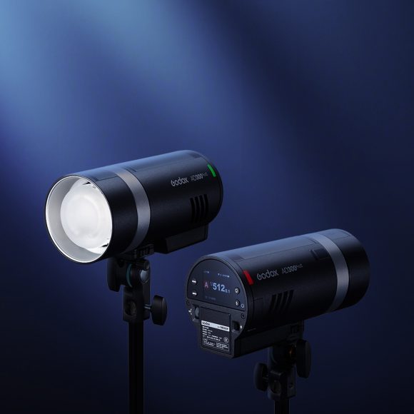Godox AD300Pro II: Your Favorite Outdoor Strobe Gets Better Two black studio lights on stands illuminated against a dark blue background with a spotlight effect.