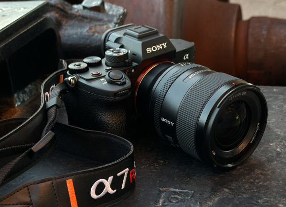 What Cameras Will Sony Launch in 2026? A Sony Alpha camera with a zoom lens and branded strap resting on a metal surface.