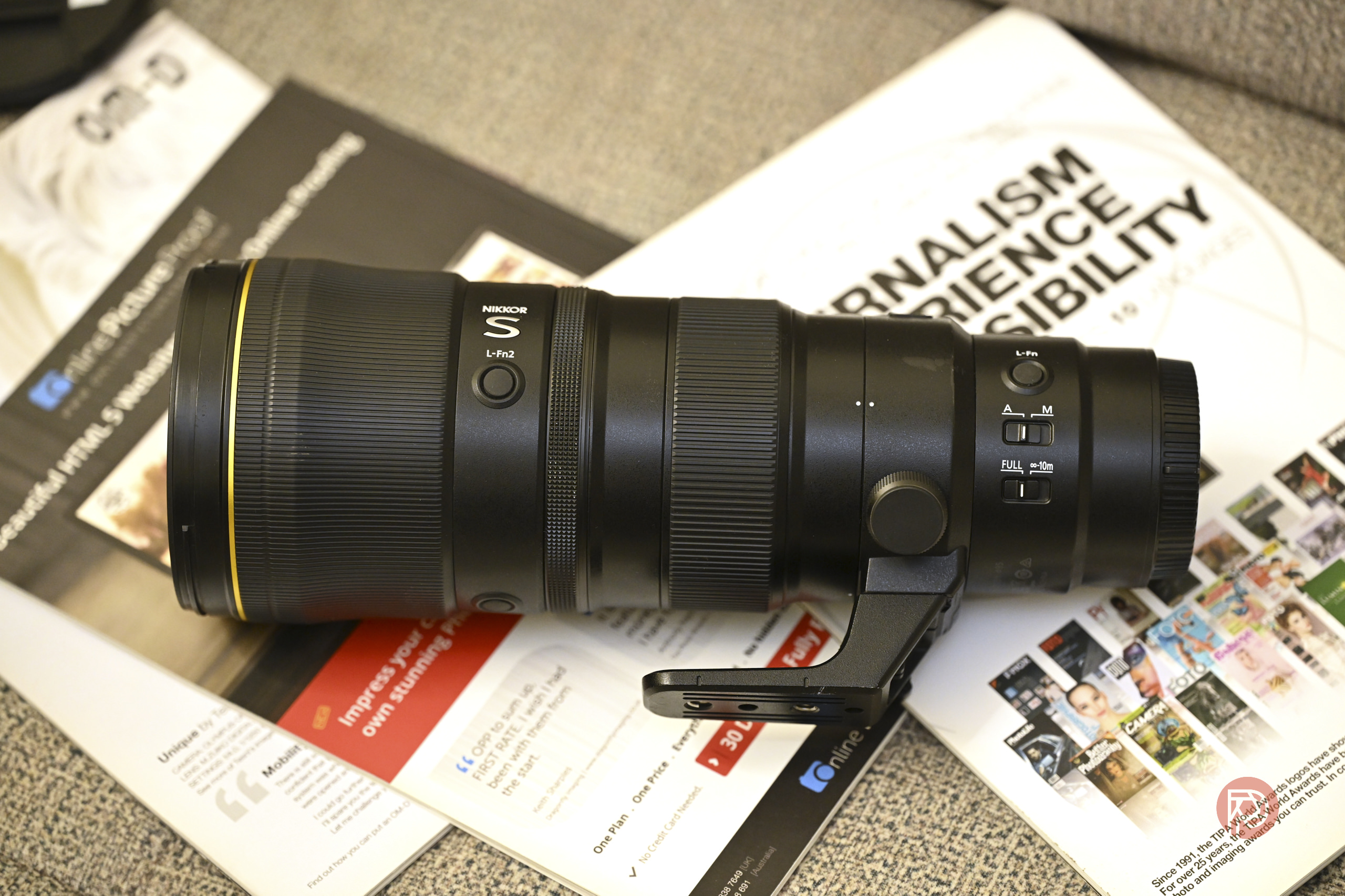 Nikon Z 600mm f6.3 Review: A Top-Notch, Affordable Super Telephoto A Nikon telephoto camera lens rests on magazines and papers on a desk.