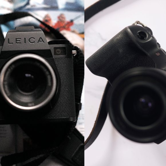 Close-up of a Leica camera on the left and a Canon EOS camera on the right, both with attached straps.