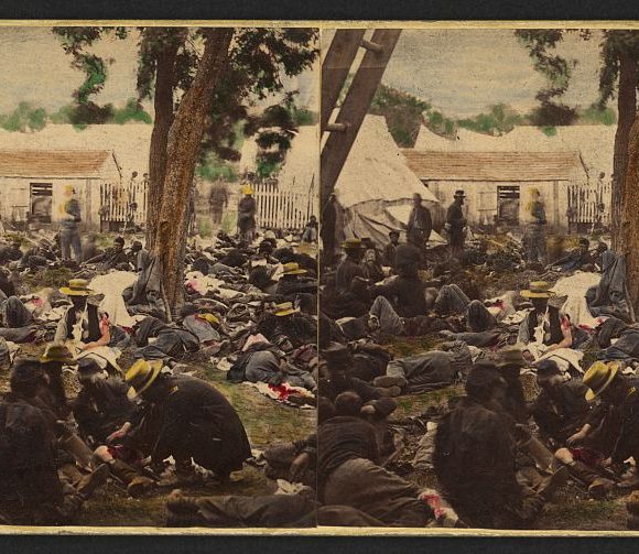 Civil War soldiers receiving medical care outdoors, with tents and trees in the background.