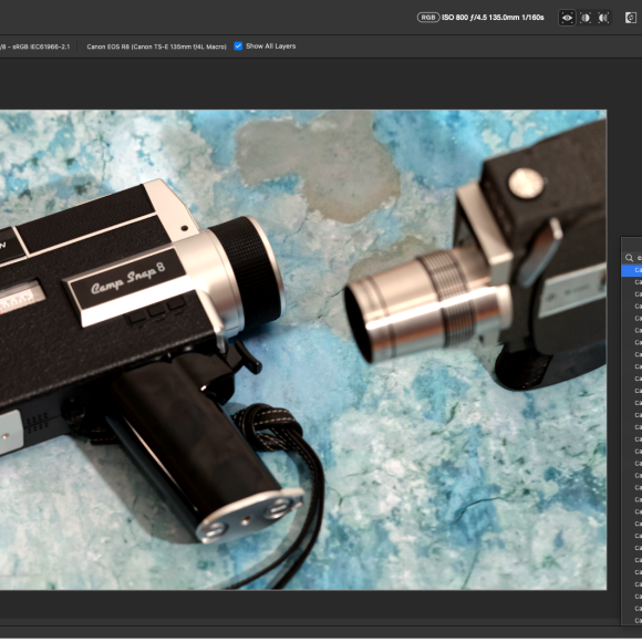 A vintage Super 8 video camera on a blue marbled surface, with another camera partially visible.