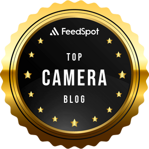 Gold badge with FeedSpot Top Camera Blog and small stars around the border.