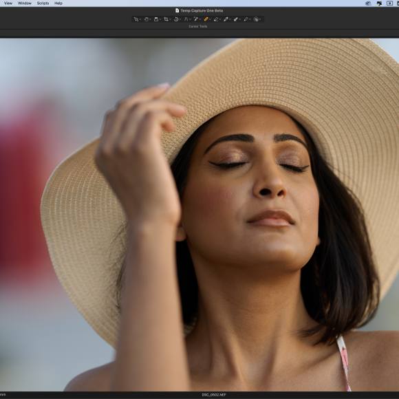 A woman in a sunhat with closed eyes poses calmly for a portrait on a photo editing software screen.