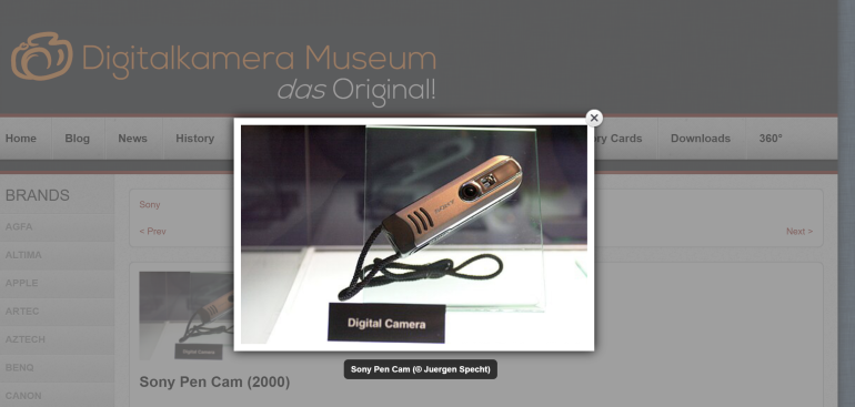 Close-up of a Sony Pen Cam digital camera displayed on a stand with a wrist strap.